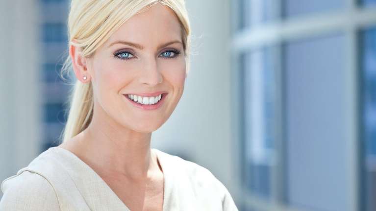 Blonde woman with porcelain veneers smiling, charlotte nc